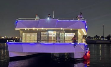 مشهد ليلي خلاب من يخت فاخر أثناء رحلة بحرية في قناة دبي