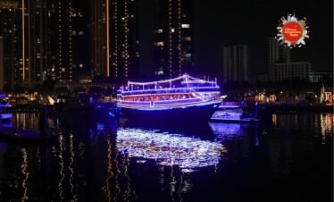 Dubai Canal Dinner Cruise at night with luxury dhow illuminated by LED lights